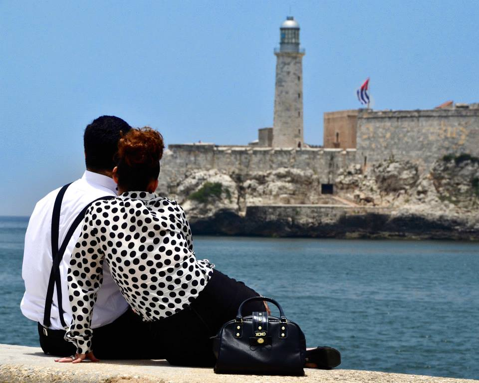 Pareja en el malecón de la Habana mirando al castillo del morro