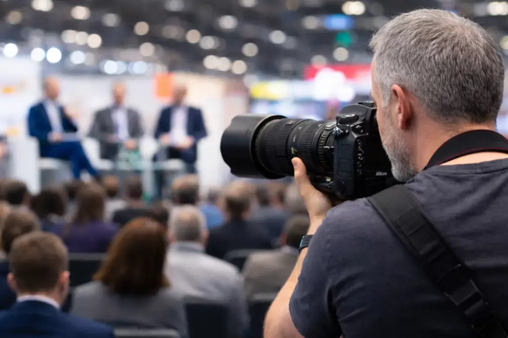 Fotógrafo de eventos captando una conferencia con cámara Nikon